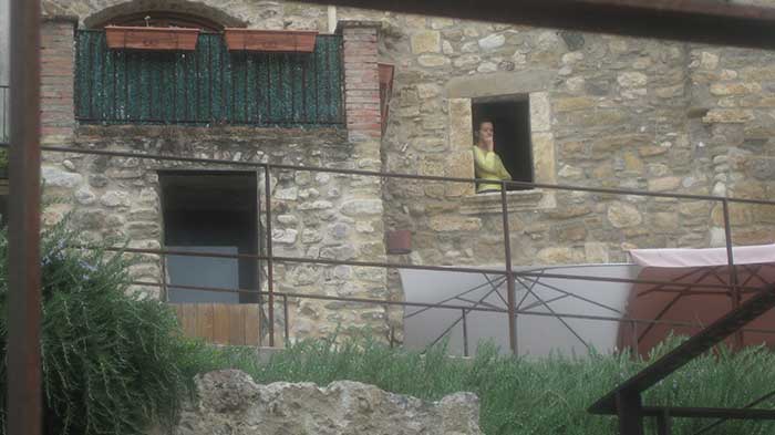 Cual moza medieval esta joven goza de la vista desde el balcón de la mikve.