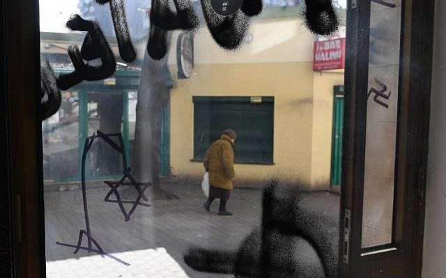 El antisemitismo polaco prolifera en Internet 1 Una mujer pasa por una ventana con una esvástica y un dibujo de una estrella de David judía en la horca, en el edificio del movimiento Ciudadanos de Polonia (Obywatele RP) el 26 de febrero de 2019 en Varsovia, Polonia. (Janek Skarzynski / AFP)