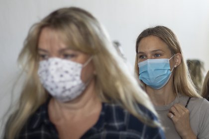 La modelo israelí Bar Refaeli (derecha) y su madre Zipi Refaeli portan mascarillas mientras abandonan una sala del tribunal de Tel Aviv, Israel, el domingo 13 de septiembre de 2020. (AP Foto/Ariel Schalit, Pool)