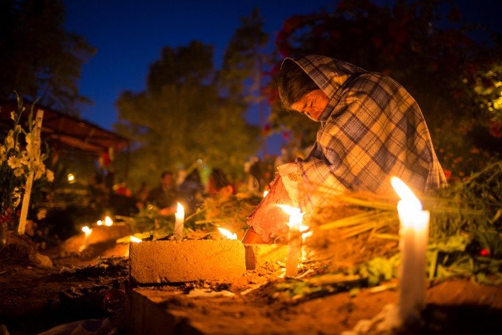 Las personas dan ofrendas a las almas de los difuntos. Foto: EFE