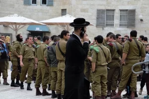 Un hombre ultraortodoxo judia habla por telefono junto a soldados israelies en el barrio judio de la Ciudad Vieja de Jerusalen Foto Raimund Andree via Pixabay