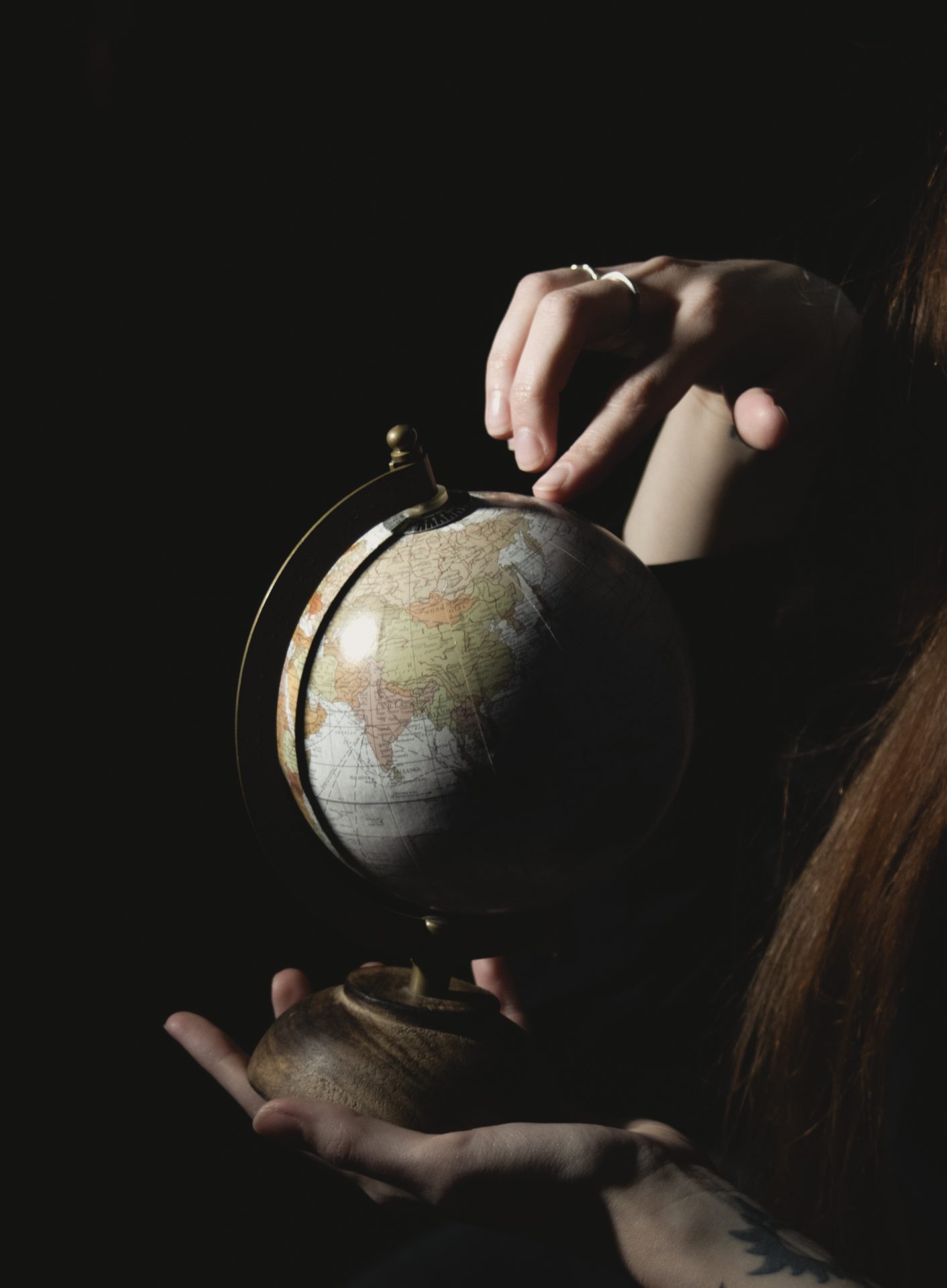 a young girl in a dark room holding a globe in he 2023 05 13 01 31 49 utc