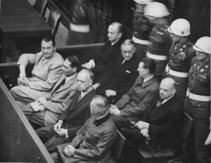 Juicios de Nuremberg . Los acusados ​​en su banquillo, de izquierda a derecha Hermann Göring, Rudolf Heß, Joachim von Ribbentrop, Wilhelm Keitel, Karl Dönitz, Erich Raeder, Baldur von Schirach, Fritz Sauckel. Foto: English: Work of the United States Government, Public domain, via Wikimedia Commons.