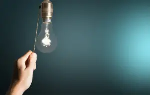 depositphotos 118556734 stock photo hand turning off the bulb